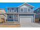 Charming two-story home with a blue exterior, a white garage door, and a well-manicured front lawn at 6531 14Th St, Frederick, CO 80530