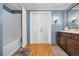 Bright bathroom featuring double doors, a shower/tub, and a wood vanity at 39 Pat Creek Rd, Evergreen, CO 80439