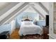 Attic bedroom space with white beams, hardwood floor, and a window at 39 Pat Creek Rd, Evergreen, CO 80439