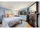 Cozy bedroom with large window, fireplace, decorative mirror, and hardwood floors at 39 Pat Creek Rd, Evergreen, CO 80439