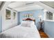 Cozy attic bedroom with hardwood floors, white ceiling beams, and light blue walls at 39 Pat Creek Rd, Evergreen, CO 80439