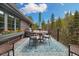 Beautiful deck with dining table, grill, and comfortable seating with views of the surrounding trees at 39 Pat Creek Rd, Evergreen, CO 80439