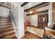 Warm foyer featuring hardwood floors, exposed beams, staircase with custom wood railing, and natural light at 39 Pat Creek Rd, Evergreen, CO 80439