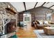 Warm, inviting living room with log walls, stone fireplace, and comfortable seating area at 39 Pat Creek Rd, Evergreen, CO 80439
