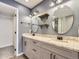 Stylish bathroom featuring dual sinks, modern vanity, decorative mirrors and lights, and a walk-in shower at 9813 E Carolina Pl, Aurora, CO 80247