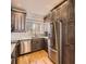 Well-equipped kitchen featuring stainless steel appliances, granite countertops, and wooden floors at 9813 E Carolina Pl, Aurora, CO 80247
