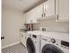 Laundry room with granite countertops, front loading washer and dryer, and ample cabinet space at 9813 E Carolina Pl, Aurora, CO 80247