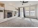 Bright and airy living room with a decorative fireplace, large windows, and a ceiling fan at 9813 E Carolina Pl, Aurora, CO 80247