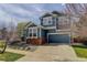 Inviting two-story home with a two car garage, stone accents, and an appealing blue facade at 9996 Sedalia St, Commerce City, CO 80022