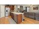 Stylish kitchen with a stainless steel refrigerator, large island, and open view to the living room at 9996 Sedalia St, Commerce City, CO 80022