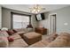 A cozy living room with a sectional couch, fan, and natural light at 9996 Sedalia St, Commerce City, CO 80022