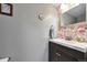 Charming half-bathroom with floral wallpaper, stylish vanity, and decorative mirror at 36545 Winchester Rd, Elizabeth, CO 80107