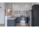 Modern kitchen with stainless steel appliances, dark cabinets, and wooden shelving at 10035 E Carolina Pl # 201, Aurora, CO 80247