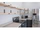 Kitchen with stainless steel appliances, open wood shelving, and neutral countertops and cabinetry at 10035 E Carolina Pl # 201, Aurora, CO 80247