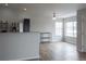 Open living room with kitchen bar, large window, light fixture and stainless steel appliances at 10035 E Carolina Pl # 201, Aurora, CO 80247