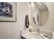Stylish powder room with a round mirror, unique artwork, and a clean, modern design at 3228 47Th, Boulder, CO 80301