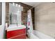 Clean bathroom with a red vanity, bathtub, and tile shower surround at 5370 Pine Ridge Rd, Golden, CO 80403