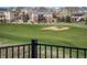 Backyard view of neighborhood homes across a lush green golf course and sand trap at 7965 S Vandriver Way, Aurora, CO 80016