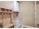 Functional mud room with hooks, a bench, cabinets, and a small countertop at 7965 S Vandriver Way, Aurora, CO 80016
