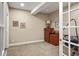 Home office with neutral walls and carpet features a large closet with dark brown dresser at 7965 S Vandriver Way, Aurora, CO 80016