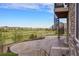 Outdoor patio with stone flooring and a spiral staircase overlooks a lush golf course and green space at 7965 S Vandriver Way, Aurora, CO 80016