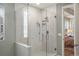 Modern glass shower with patterned accent wall, multiple shower heads, and a tiled floor at 7965 S Vandriver Way, Aurora, CO 80016