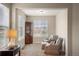 Cozy sitting area featuring two chairs, an ottoman, a hutch, and a large window at 7965 S Vandriver Way, Aurora, CO 80016