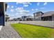 Well-maintained backyard with green grass and white fence, offering privacy and a neighborhood view at 8888 Falcon St, Longmont, CO 80504