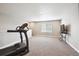Large, carpeted bonus room featuring a television and treadmill at 8888 Falcon St, Longmont, CO 80504