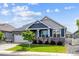 Charming blue two-story home with landscaped yard, stone accents, and a covered porch with rocking chairs at 8888 Falcon St, Longmont, CO 80504