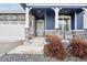 Inviting front porch with stone accents, rocking chairs, and a blue planter at 8888 Falcon St, Longmont, CO 80504