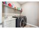 Functional laundry room featuring modern washer and dryer units, a sink, and ample storage space at 8888 Falcon St, Longmont, CO 80504