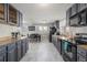 Modern kitchen with gray cabinets, marble floor, and stainless steel appliances at 7674 Stuart St, Westminster, CO 80030