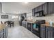 Modern kitchen with gray cabinets, marble floor, and stainless steel appliances at 7674 Stuart St, Westminster, CO 80030