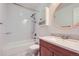 Bathroom with granite countertops, wood cabinets, and a white tub and shower combination at 8136 Washington St # 141, Denver, CO 80229
