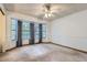Large bedroom with big bay windows, neutral carpeting, ceiling fan, and base trim at 8136 Washington St # 141, Denver, CO 80229