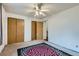 Bedroom with double closets, neutral walls, ceiling fan and colorful flower-patterned rug at 8136 Washington St # 141, Denver, CO 80229