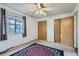 Bedroom with a view out the window, double closets, ceiling fan and decorative rug at 8136 Washington St # 141, Denver, CO 80229