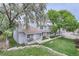 Townhome exterior view showing lawn, front decks, and mature trees at 8136 Washington St # 141, Denver, CO 80229