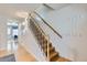 Hallway with hardwood floors, coat hooks, access to the front door, and a stairway to the upper level at 8136 Washington St # 141, Denver, CO 80229
