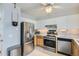 Modern kitchen with stainless steel appliances, white cabinets, and a ceiling fan at 8136 Washington St # 141, Denver, CO 80229