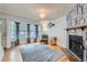 Open living room featuring a stone fireplace, hardwood floors, and a bay window at 8136 Washington St # 141, Denver, CO 80229
