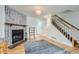 Bright living room with stone fireplace, hardwood floors, and staircase at 8136 Washington St # 141, Denver, CO 80229