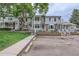 Townhome street view showcasing the front facades, with parking spots and green lawn at 8136 Washington St # 141, Denver, CO 80229
