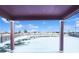 View of the snow-covered backyard with a wooden fence and partially covered patio at 3520 Little Bell Dr, Frederick, CO 80516