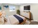 Bright staged bedroom featuring hardwood floors, modern decor, a window, and a TV at 3520 Little Bell Dr, Frederick, CO 80516