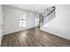 Bright entryway featuring wood-look floors, a staircase with white risers, and plenty of natural light at 3520 Little Bell Dr, Frederick, CO 80516