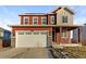 Two-story home featuring a two-car garage and a red and gray exterior at 3520 Little Bell Dr, Frederick, CO 80516