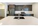 Modern kitchen island with stainless steel appliances, dark cabinetry, and ample storage at 3520 Little Bell Dr, Frederick, CO 80516
