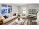 Bright living room is virtually staged with modern furniture, natural light, and hardwood floors at 3520 Little Bell Dr, Frederick, CO 80516